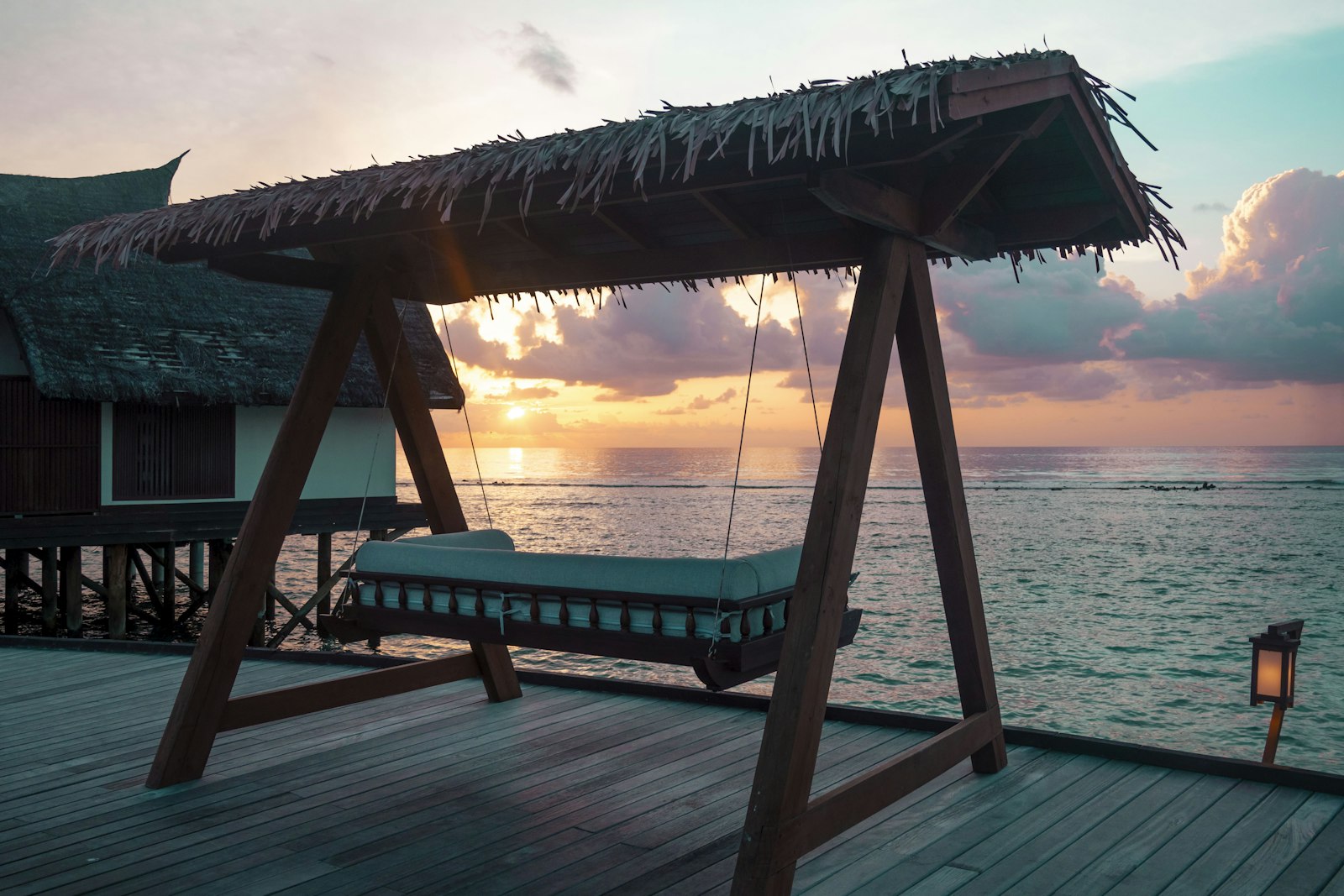 a swing bed sitting on top of a wooden pier
