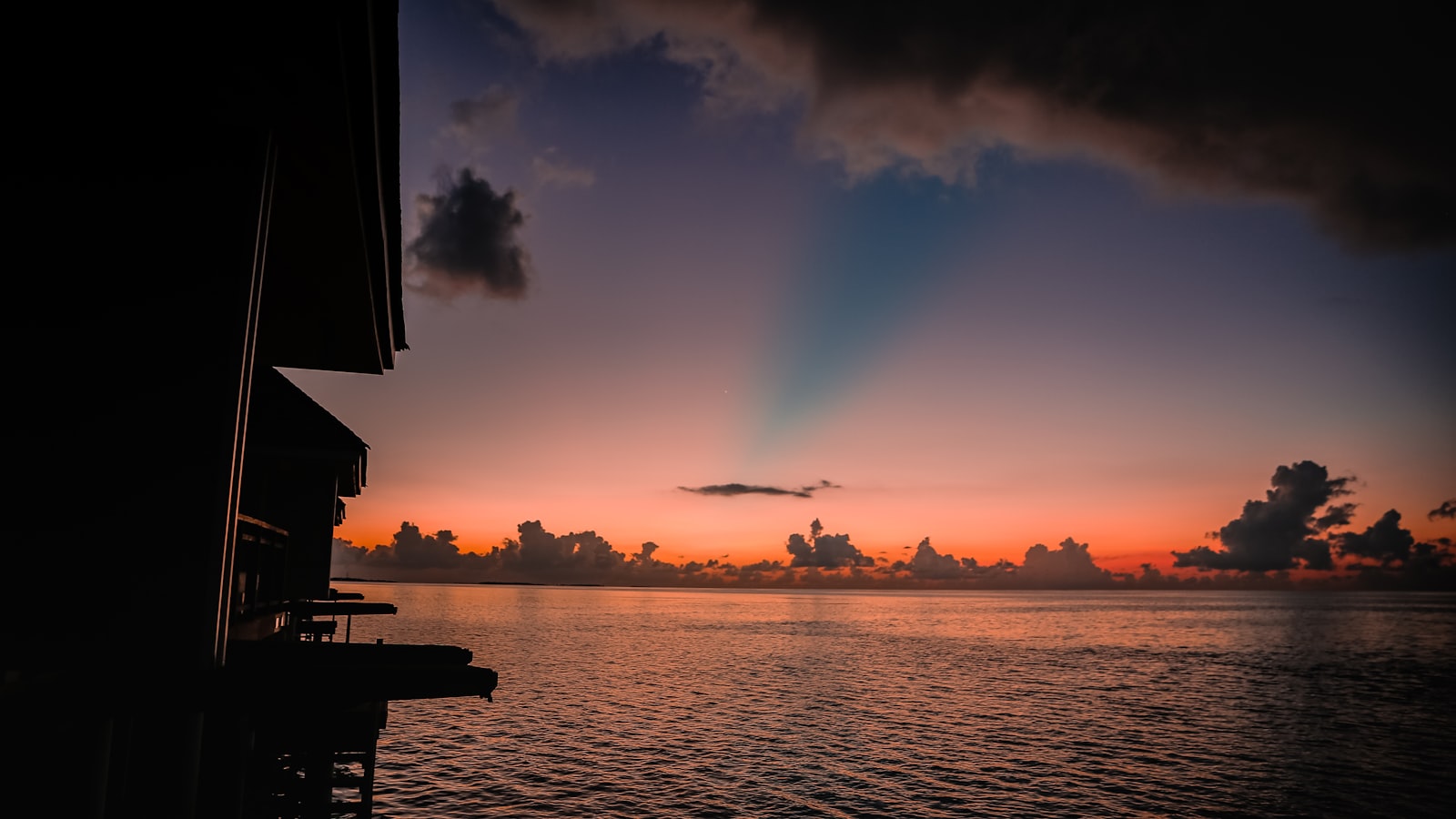 Sunset over a calm ocean with clouds